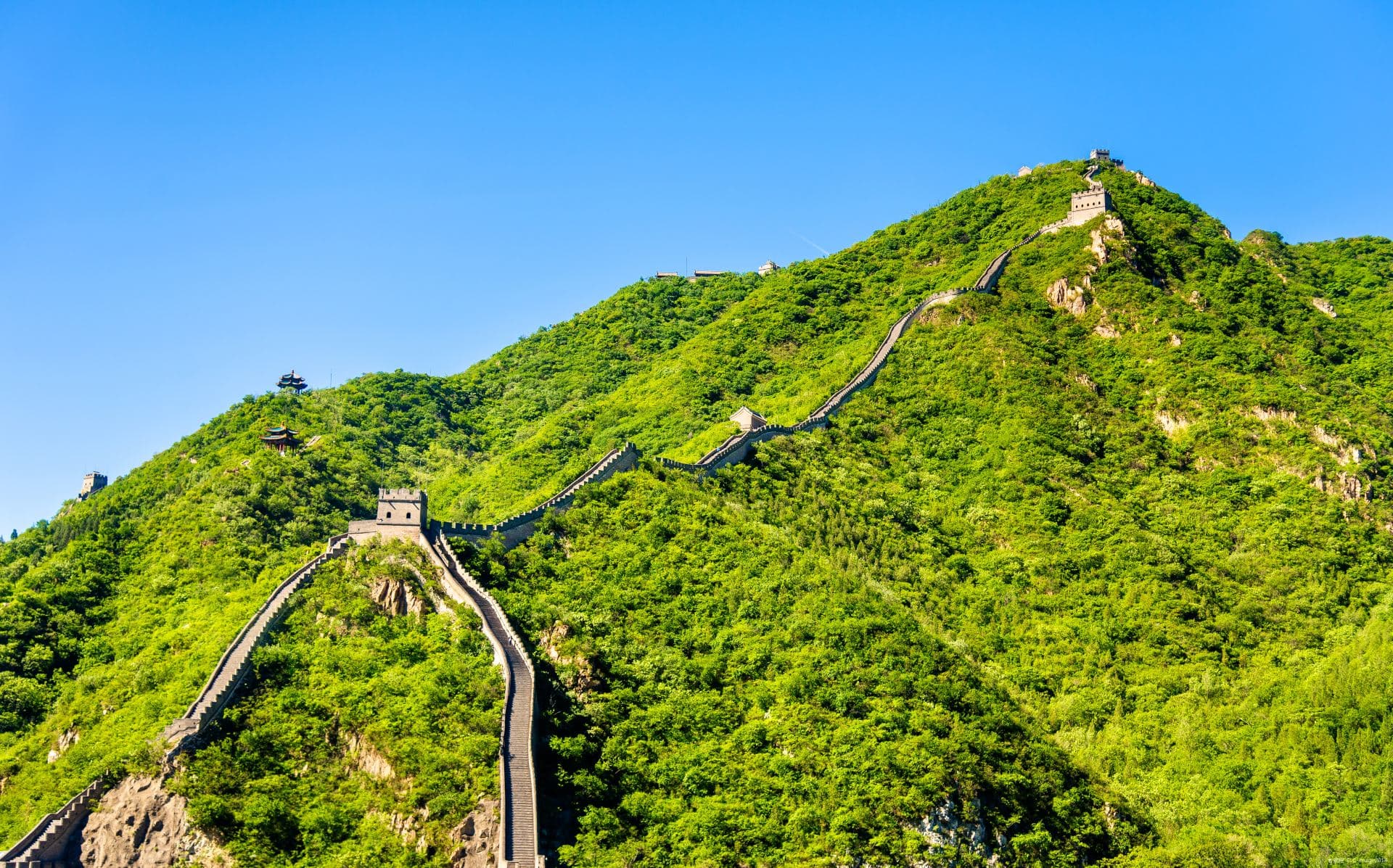 Great Wall and watchtowers climbing the green hillsides at Juyongguan