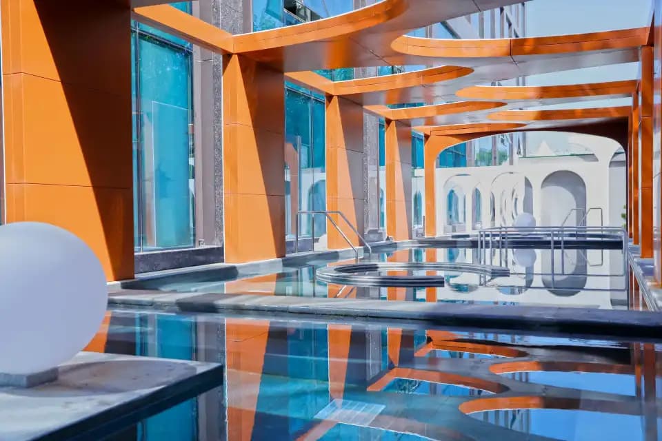 Xishan bathing pools beneath orange beams, beside white arches and glass walls; photograph taken before renovation