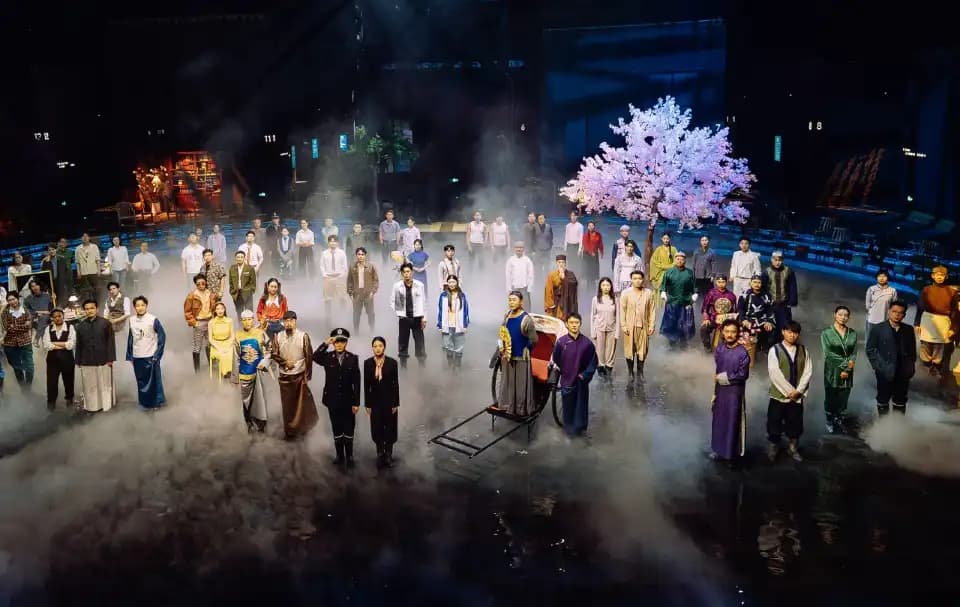 Performers on a mist-filled stage beside a pink tree and theatrical sets at Unique Dream of Red Mansion.