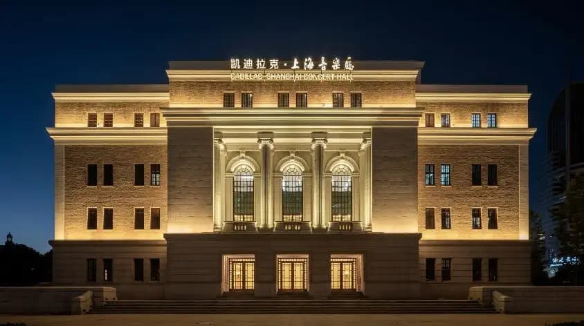 Illuminated facade of Shanghai Concert Hall with columns and arched windows
