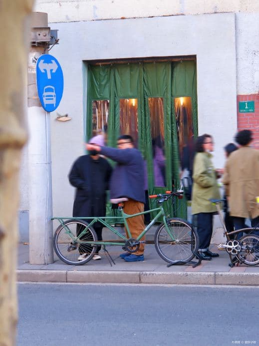 Green entrance of Slab Town on Fumin Road with visitors and bicycles