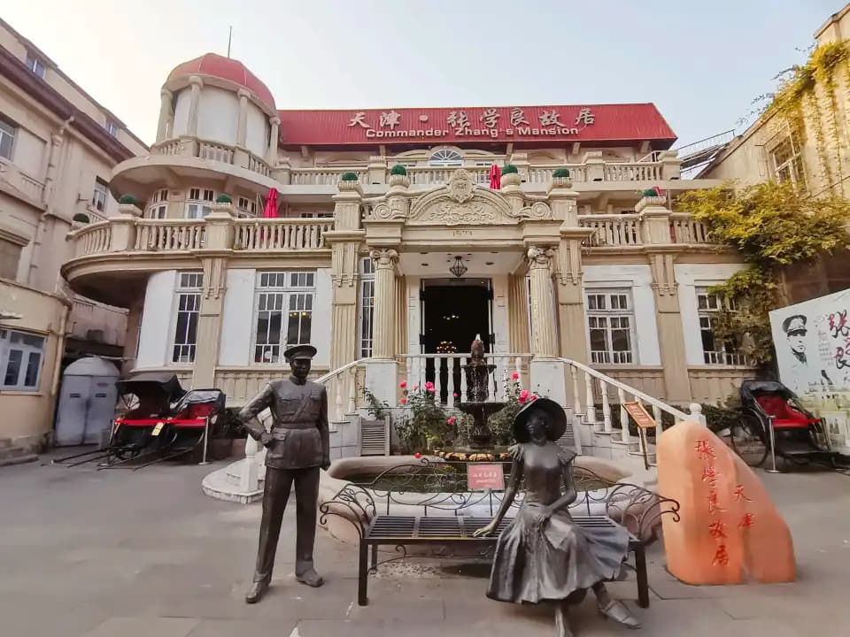 Zhang Xueliang’s house in Tianjin, with a pale balcony facade and statues in the courtyard