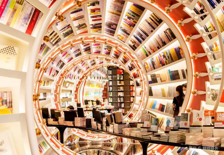 Red-and-white bookshelves forming a horizontal spiral inside Zhongshuge at OH Bay